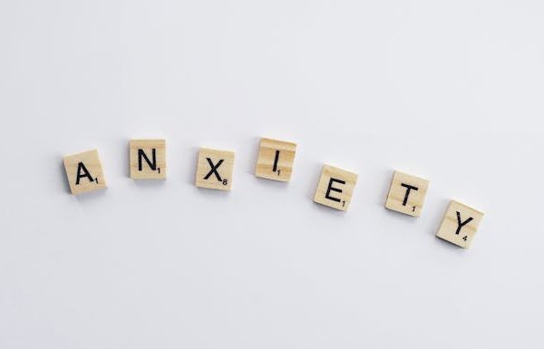 White and Brown Wooden Tiles each with a letter that spells Anxiety which is representation of the article