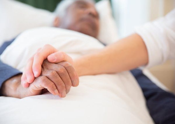 Young Persons Hand Holding an elderly to show empathy and care during palliative care